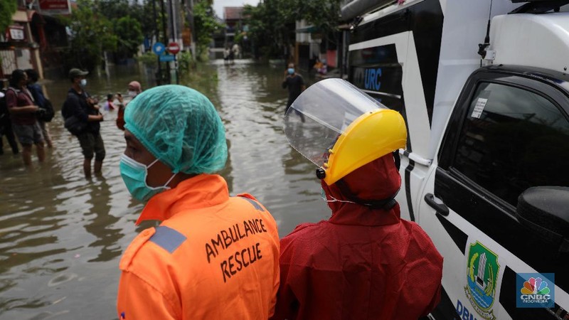 Nakes menjemput pasien covid-19 di tengah banjir. (CNBC Indonesia/ Muhammad Sabki)