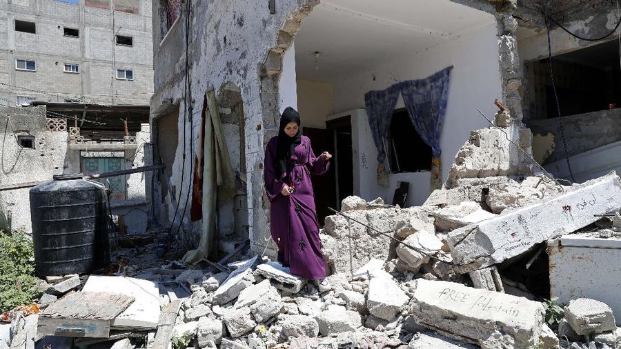 Pekerja memindahkan puing-puing bangunan yang hancur akibat serangan udara Israel, di Kota Gaza, Selasa, (15/6/2021). (AP/Tsafrir Abayov)