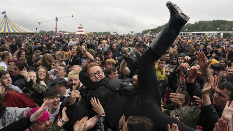 Penonton festival menyaksikan band rock Death Blooms di atas panggung pada hari pertama Download Festival di Donington Park di Castle Donington, Inggris, Jumat (18/6/2021). Festival musik dan seni selama tiga hari ini digelar sebagai ajang uji coba untuk mengkaji bagaimana Covid--19 menular. (AP/Joe Giddens)