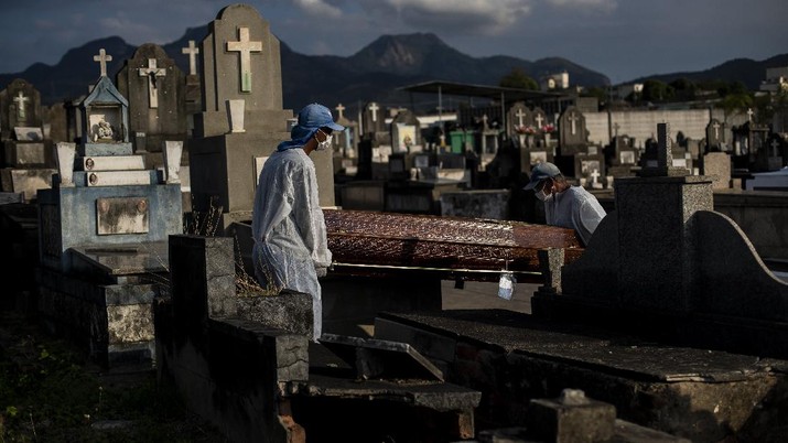 Kematian di Brasil Cemetery workers carry the coffin that contains the remains of 89-year-old Irodina Pinto Ribeiro, who died from COVID-19 related complications, at the Inhauma cemetery in Rio de Janeiro, Brazil, Friday, June 18, 2021. Brazil is approaching an official COVID-19 death toll of 500,000 — second-highest in the world. (AP Photo/Bruna Prado)
