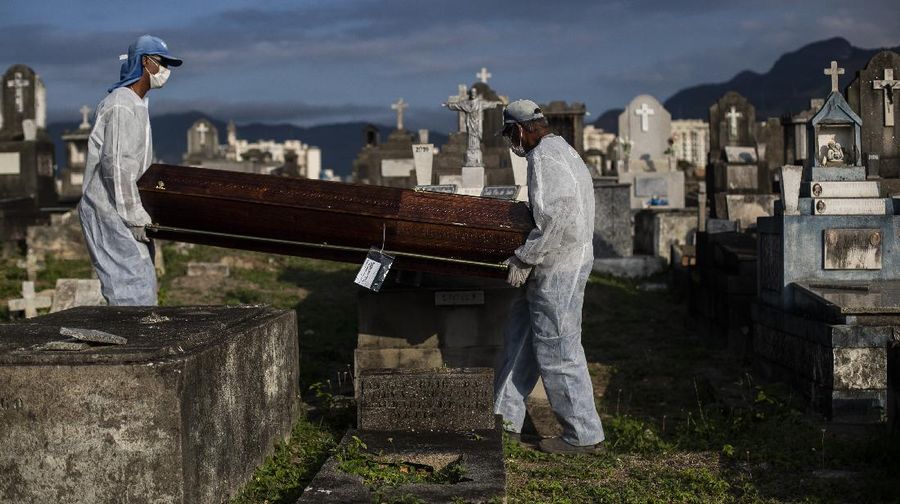 Cemetery workers carry the coffin that contains the remains of 89-year-old Irodina Pinto Ribeiro, who died from COVID-19 related complications, at the Inhauma cemetery in Rio de Janeiro, Brazil, Friday, June 18, 2021. Brazil is approaching an official COVID-19 death toll of 500,000 — second-highest in the world. (AP Photo/Bruna Prado)