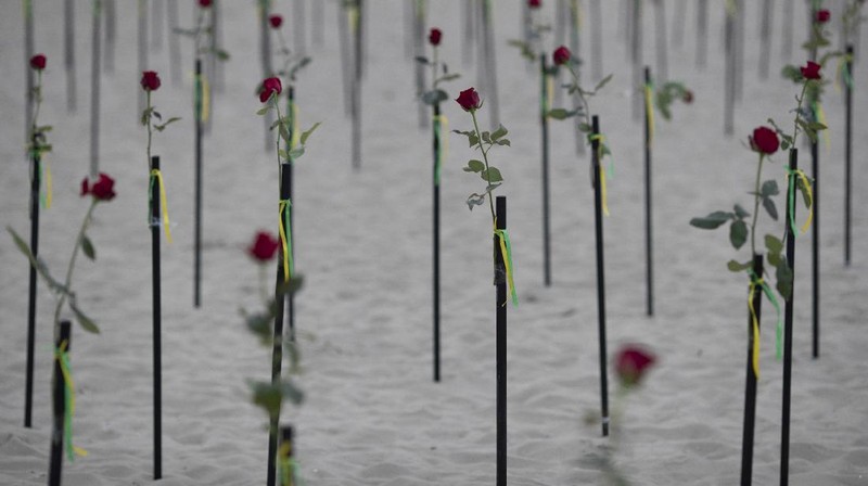 Roses are placed on Copacabana beach to honor the 500,000 COVID-19 deaths and to protest against Brazilian President Jair Bolsonaro and his handling of the COVID-19 pandemic, in Rio de Janeiro, Brazil, Sunday, June 20, 2021. Brazil's COVID-19 death toll surpassed the milestone of 500,000 deaths on Saturday night. (AP Photo/Silvia Izquierdo)