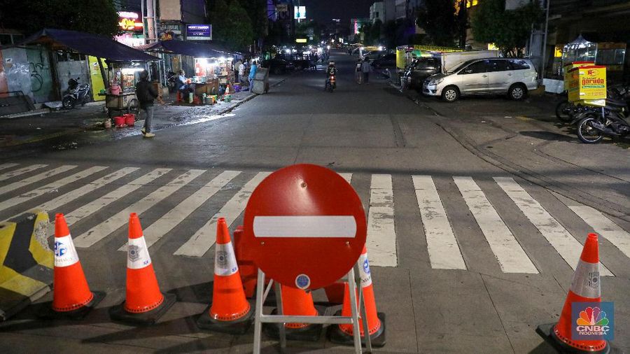 Petugas Kepolisian dan Satpol PP menutup jalan saat penerapan pembatasan mobilitas masyarakat di kawasan kuliner Jalan Sabang, Jakarta, Senin (21/6/2021). (CNBC Indonesia/ Andrean Kristianto)