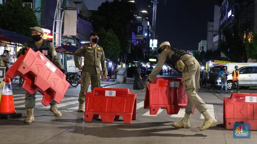 Petugas Kepolisian dan Satpol PP menutup jalan saat penerapan pembatasan mobilitas masyarakat di kawasan kuliner Jalan Sabang, Jakarta, Senin (21/6/2021). (²©²ÊÍøÕ¾/ Andrean Kristianto)