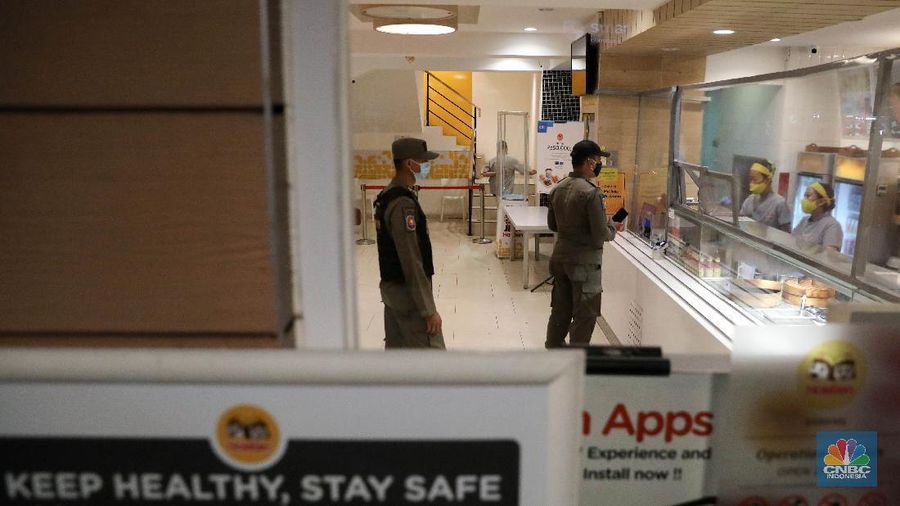 Petugas Satpol PP memberikan himbauan kepada pekerja restoran mengenai jalm pemberlakuan penerapan pembatasan mobilitas masyarakat di kawasan kuliner Jalan Sabang, Jakarta, Senin (21/6/2021). (CNBC Indonesia/ Andrean Kristianto)