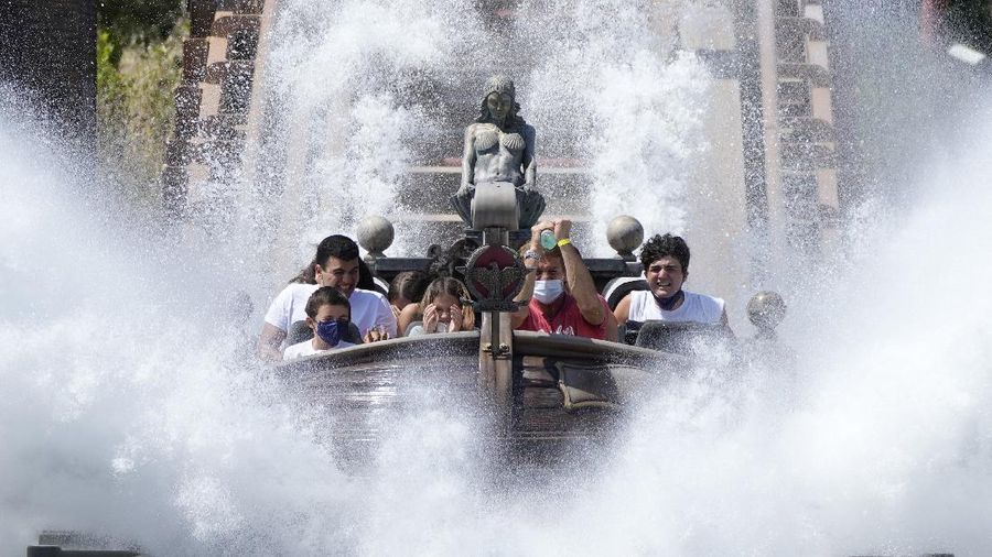 Visitors ride a roller coaster at Cinecitta World amusement park in the outskirts of Rome in the day of its reopening, Thursday, June 17, 2021. Amusement parks have been closed since Oct. 25 2020, when Italy's second national lockdown started. (AP Photo/Alessandra Tarantino)