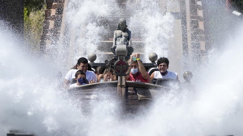 Visitors ride a roller coaster at Cinecitta World amusement park in the outskirts of Rome in the day of its reopening, Thursday, June 17, 2021. Amusement parks have been closed since Oct. 25 2020, when Italy's second national lockdown started. (AP Photo/Alessandra Tarantino)