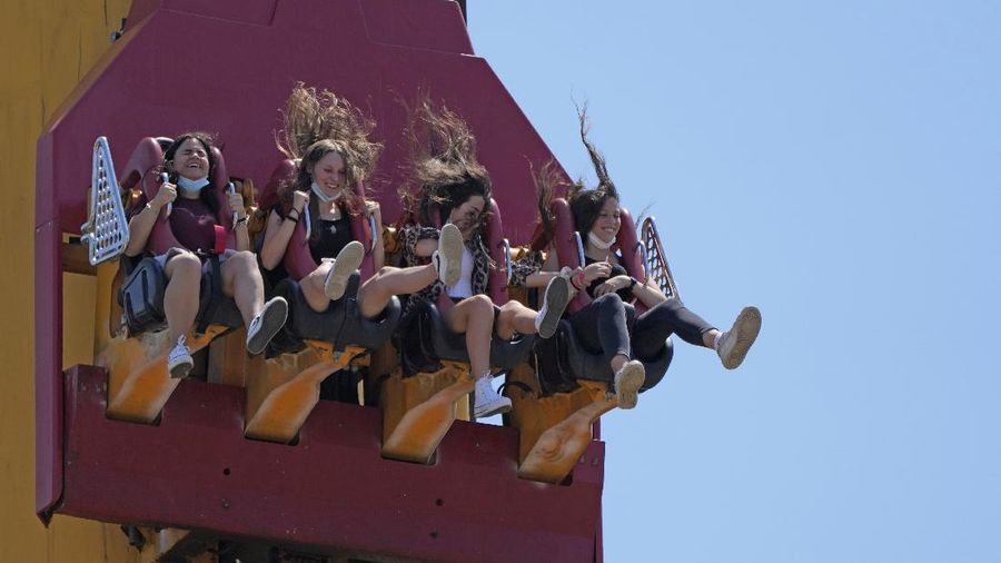 Visitors ride a roller coaster at Cinecitta World amusement park in the outskirts of Rome in the day of its reopening, Thursday, June 17, 2021. Amusement parks have been closed since Oct. 25 2020, when Italy's second national lockdown started. (AP Photo/Alessandra Tarantino)