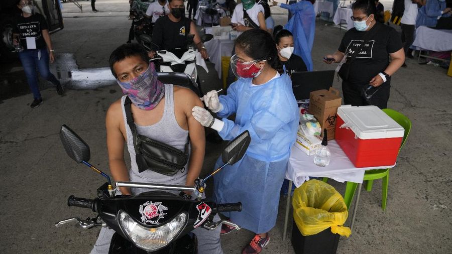 A health worker inoculates a woman with China's Sinovac COVID-19 vaccine at a temporary vaccination center in Manila, Philippines, Tuesday, June 22, 2021. The Philippine president has threatened to order the arrest of Filipinos who refuse COVID-19 vaccination and told them to leave the country for hard-hit countries like India and the United States if they would not cooperate with massive efforts to end the pandemic. (AP Photo/Aaron Favila)