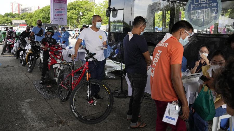 A health worker inoculates a woman with China's Sinovac COVID-19 vaccine at a temporary vaccination center in Manila, Philippines, Tuesday, June 22, 2021. The Philippine president has threatened to order the arrest of Filipinos who refuse COVID-19 vaccination and told them to leave the country for hard-hit countries like India and the United States if they would not cooperate with massive efforts to end the pandemic. (AP Photo/Aaron Favila)