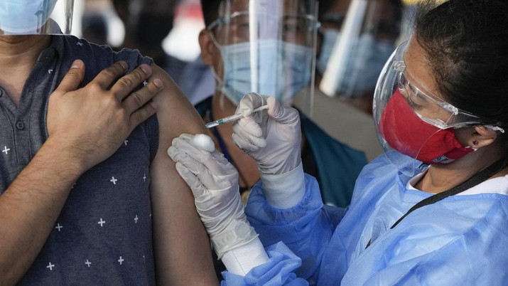 A health worker inoculates a woman with China's Sinovac COVID-19 vaccine at a temporary vaccination center in Manila, Philippines, Tuesday, June 22, 2021. The Philippine president has threatened to order the arrest of Filipinos who refuse COVID-19 vaccination and told them to leave the country for hard-hit countries like India and the United States if they would not cooperate with massive efforts to end the pandemic. (AP Photo/Aaron Favila)