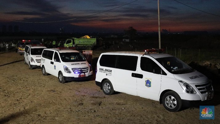 Sejumlah petugas pemakaman lengkap dengan menggunakan alat pelindung diri (APD) memakamkan jenazah Covid-19 di Tempat Pemakaman Umum (TPU) Rorotan, Kota, Jakarta Utara, Jumat (25/6/2021). (CNBC Indonesia/Andrean Kristianto)