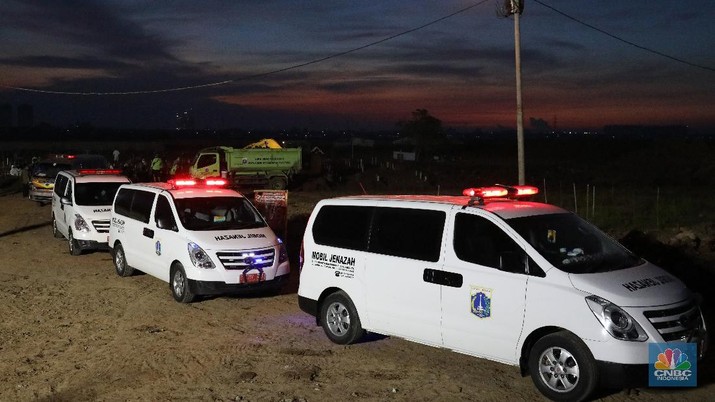 Sejumlah petugas pemakaman lengkap dengan menggunakan alat pelindung diri (APD) memakamkan jenazah Covid-19 di Tempat Pemakaman Umum (TPU) Rorotan, Kota, Jakarta Utara, Jumat (25/6/2021). (CNBC Indonesia/Andrean Kristianto)
