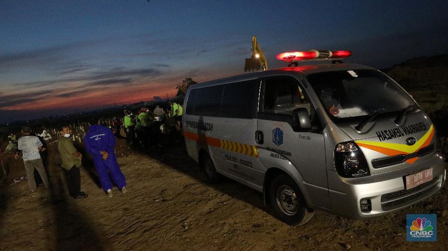 Sejumlah petugas pemakaman lengkap dengan menggunakan alat pelindung diri (APD) memakamkan jenazah Covid-19 di Tempat Pemakaman Umum (TPU) Rorotan, Kota, Jakarta Utara, Jumat (25/6/2021). (CNBC Indonesia/Andrean Kristianto)
