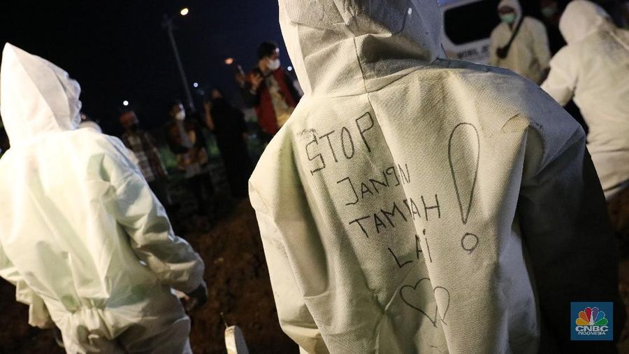 Sejumlah petugas pemakaman lengkap dengan menggunakan alat pelindung diri (APD) memakamkan jenazah Covid-19 di Tempat Pemakaman Umum (TPU) Rorotan, Kota, Jakarta Utara, Jumat (25/6/2021). (CNBC Indonesia/Andrean Kristianto)