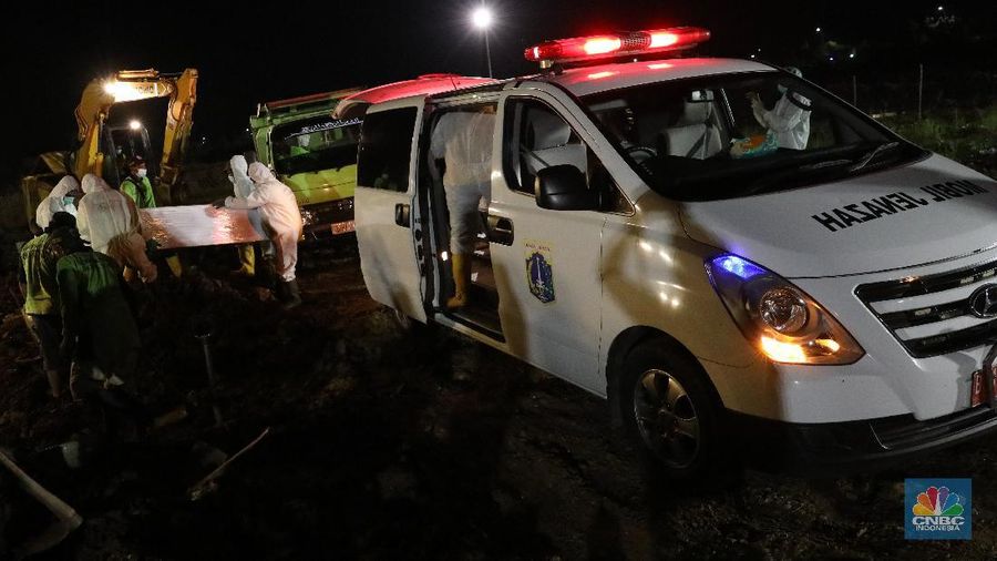 Sejumlah petugas pemakaman lengkap dengan menggunakan alat pelindung diri (APD) memakamkan jenazah Covid-19 di Tempat Pemakaman Umum (TPU) Rorotan, Kota, Jakarta Utara, Jumat (25/6/2021). (CNBC Indonesia/Andrean Kristianto)