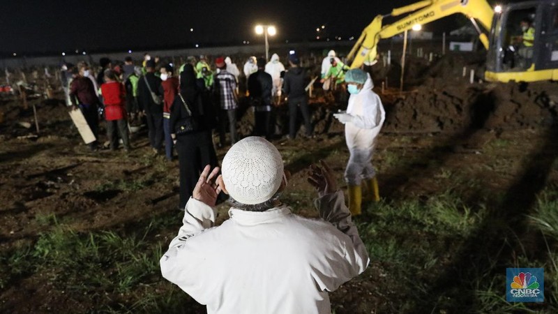 Sejumlah petugas pemakaman lengkap dengan menggunakan alat pelindung diri (APD) memakamkan jenazah Covid-19 di Tempat Pemakaman Umum (TPU) Rorotan, Kota, Jakarta Utara, Jumat (25/6/2021). (CNBC Indonesia/Andrean Kristianto)