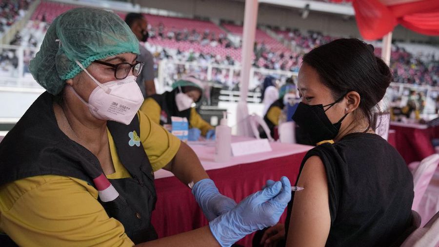 People line up to get vaccinated with the Sinovac COVID-19 vaccine during a mass vaccination at Gelora Bung Karno Main Stadium in Jakarta, Indonesia, Saturday, June 26, 2021. The world's fourth most populous country, has seen COVID-19 infections surge in recent weeks, putting pressure on hospitals, including in the capital city, where most of hospital beds are full, and has added urgency to the government's plan to inoculate 1 million people each day by next month. (AP Photo/Dita Alangkara)