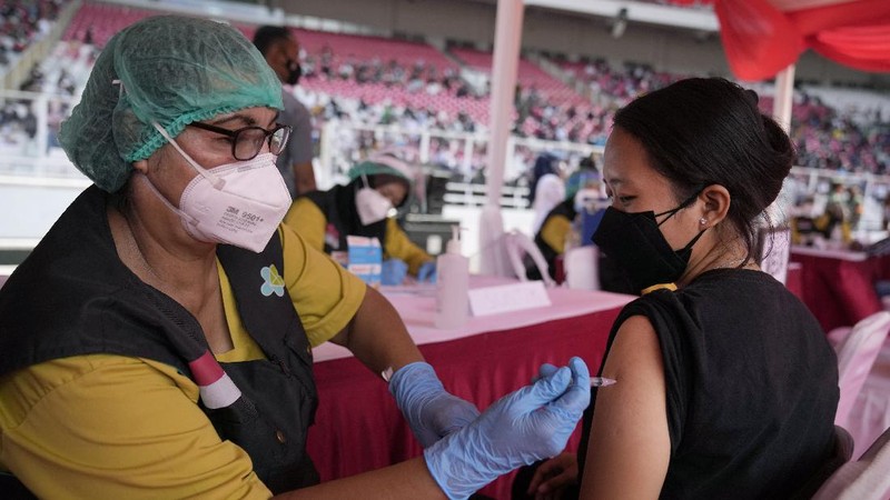 People line up to get vaccinated with the Sinovac COVID-19 vaccine during a mass vaccination at Gelora Bung Karno Main Stadium in Jakarta, Indonesia, Saturday, June 26, 2021. The world's fourth most populous country, has seen COVID-19 infections surge in recent weeks, putting pressure on hospitals, including in the capital city, where most of hospital beds are full, and has added urgency to the government's plan to inoculate 1 million people each day by next month. (AP Photo/Dita Alangkara)