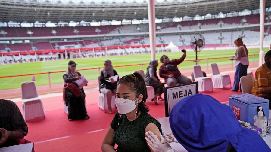 People line up to get vaccinated with the Sinovac COVID-19 vaccine during a mass vaccination at Gelora Bung Karno Main Stadium in Jakarta, Indonesia, Saturday, June 26, 2021. The world's fourth most populous country, has seen COVID-19 infections surge in recent weeks, putting pressure on hospitals, including in the capital city, where most of hospital beds are full, and has added urgency to the government's plan to inoculate 1 million people each day by next month. (AP Photo/Dita Alangkara)