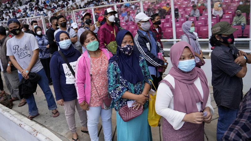 People line up to get vaccinated with the Sinovac COVID-19 vaccine during a mass vaccination at Gelora Bung Karno Main Stadium in Jakarta, Indonesia, Saturday, June 26, 2021. The world's fourth most populous country, has seen COVID-19 infections surge in recent weeks, putting pressure on hospitals, including in the capital city, where most of hospital beds are full, and has added urgency to the government's plan to inoculate 1 million people each day by next month. (AP Photo/Dita Alangkara)