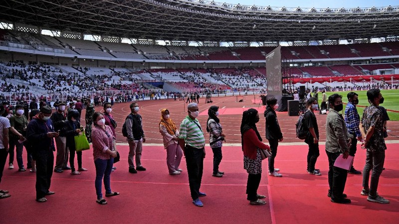 People line up to get vaccinated with the Sinovac COVID-19 vaccine during a mass vaccination at Gelora Bung Karno Main Stadium in Jakarta, Indonesia, Saturday, June 26, 2021. The world's fourth most populous country, has seen COVID-19 infections surge in recent weeks, putting pressure on hospitals, including in the capital city, where most of hospital beds are full, and has added urgency to the government's plan to inoculate 1 million people each day by next month. (AP Photo/Dita Alangkara)