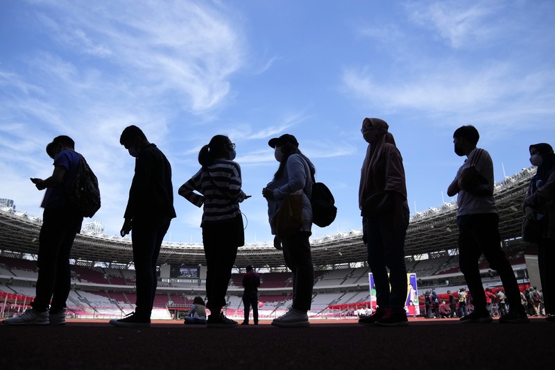 People line up to get vaccinated with the Sinovac COVID-19 vaccine during a mass vaccination at Gelora Bung Karno Main Stadium in Jakarta, Indonesia, Saturday, June 26, 2021. The world's fourth most populous country, has seen COVID-19 infections surge in recent weeks, putting pressure on hospitals, including in the capital city, where most of hospital beds are full, and has added urgency to the government's plan to inoculate 1 million people each day by next month. (AP Photo/Dita Alangkara)