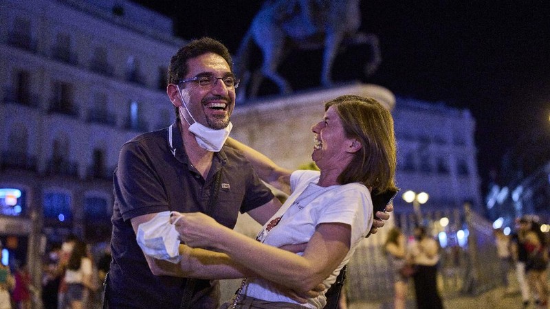 Women without wearing face masks enter into the inside of a bar in Madrid, Spain, early Saturday, June 26, 2021. Almost a year after face masks became mandatory indoors and outdoors, people from Saturday will no longer be required to wear them outside as long as they can stay at least 1.5 meters (5 feet) apart. (AP Photo/Manu Fernandez)