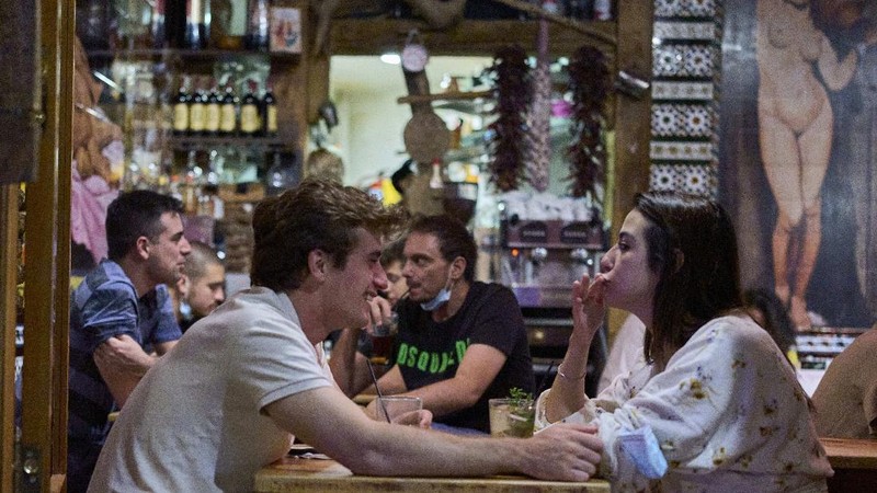 Women without wearing face masks enter into the inside of a bar in Madrid, Spain, early Saturday, June 26, 2021. Almost a year after face masks became mandatory indoors and outdoors, people from Saturday will no longer be required to wear them outside as long as they can stay at least 1.5 meters (5 feet) apart. (AP Photo/Manu Fernandez)