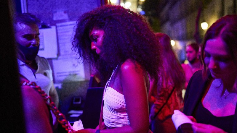 Women without wearing face masks enter into the inside of a bar in Madrid, Spain, early Saturday, June 26, 2021. Almost a year after face masks became mandatory indoors and outdoors, people from Saturday will no longer be required to wear them outside as long as they can stay at least 1.5 meters (5 feet) apart. (AP Photo/Manu Fernandez)