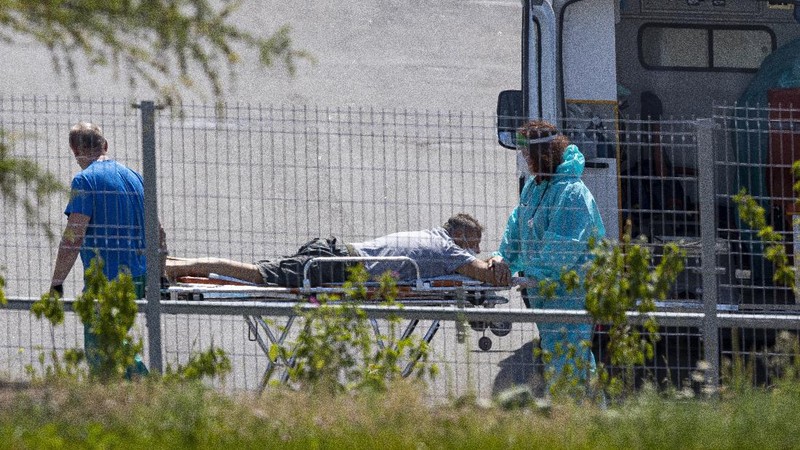 Medical workers carry a patient suspected of having coronavirus on a stretcher at a hospital in Kommunarka, outside Moscow, Russia, Saturday, June 26, 2021. Russia on Saturday reported its highest daily COVID-19 death toll of the year as the country grapples with a sharp spike in infections that has brought new restrictions in some regions. The national coronavirus task force said 619 people died over the past day, the most since Dec. 24. There were were 21,665 new infection cases, nearly 1,300 more than on the previous day and more than double the 9,500 reported on June 1. (AP Photo/Alexander Zemlianichenko)