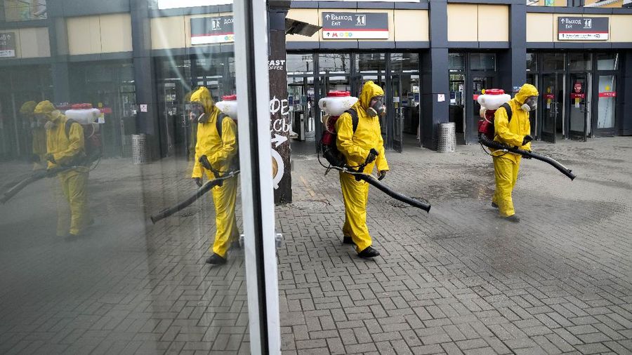 Employees of the Federal State Center for Special Risk Rescue Operations of Russia Emergency Situations, disinfect a platform of Savyolovsky railway station in Moscow, Russia, Friday, June 25, 2021. Russia reported over 20,000 new COVID-19 cases on Friday, including 7,916 in Moscow, taking the official national tally since the pandemic began to over 5,400,000. (AP Photo/Alexander Zemlianichenko)