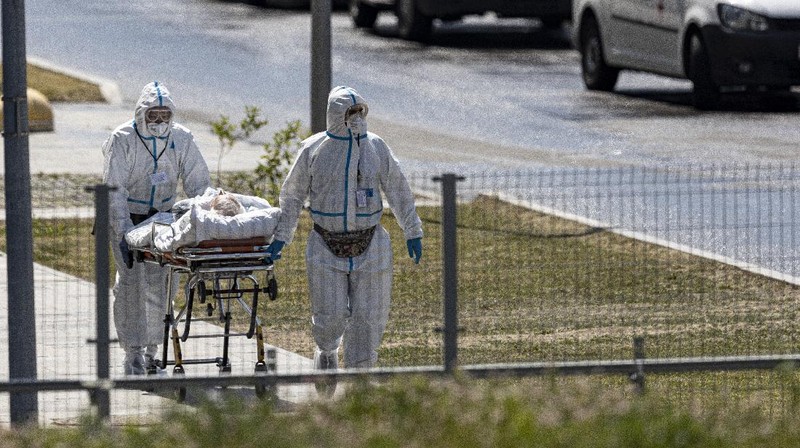 Medical workers carry a patient suspected of having coronavirus on a stretcher at a hospital in Kommunarka, outside Moscow, Russia, Saturday, June 26, 2021. Russia on Saturday reported its highest daily COVID-19 death toll of the year as the country grapples with a sharp spike in infections that has brought new restrictions in some regions. The national coronavirus task force said 619 people died over the past day, the most since Dec. 24. There were were 21,665 new infection cases, nearly 1,300 more than on the previous day and more than double the 9,500 reported on June 1. (AP Photo/Alexander Zemlianichenko)