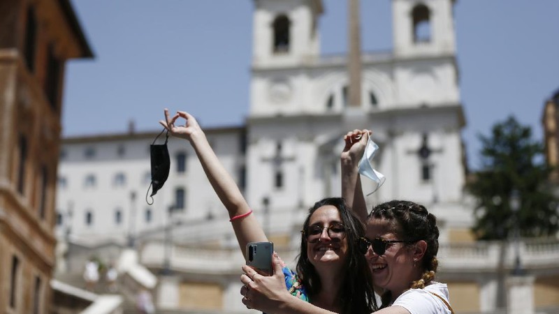 People gather and walk in front of the Trevi fountain in Rome, Monday, June 28, 2021. Italians took off their face masks and breathed a huge sigh of relief on Monday as the government-imposed requirement on mask wearing outdoors was lifted. Italian Health Minister Roberto Speranza made the decision last week to lift the outdoor mask-wearing requirement on advice from Italy’s Scientific Technical Committee (CTS) that made the decision based on the stabilisation of Italy Covid-19 indicators. (Cecilia Fabiano/LaPresse via AP)