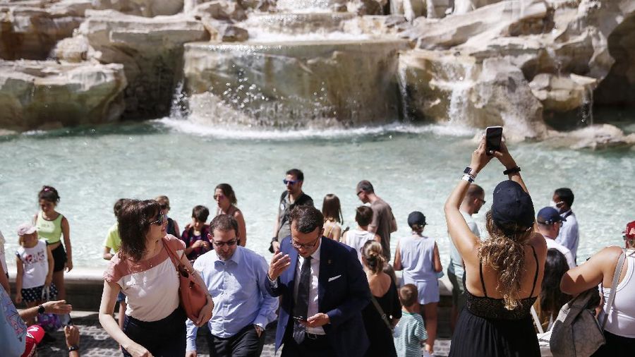People gather in front of the Trevi fountain in Rome, Monday, June 28, 2021. Italians took off their face masks and breathed a huge sigh of relief on Monday as the government-imposed requirement on mask wearing outdoors was lifted. Italian Health Minister Roberto Speranza made the decision last week to lift the outdoor mask-wearing requirement on advice from Italy’s Scientific Technical Committee (CTS) that made the decision based on the stabilisation of Italy Covid-19 indicators. (Cecilia Fabiano/LaPresse via AP)