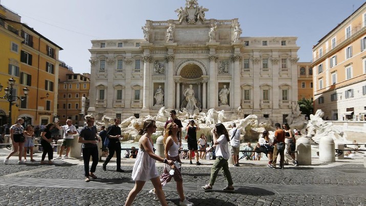 People gather and walk in front of the Trevi fountain in Rome, Monday, June 28, 2021. Italians took off their face masks and breathed a huge sigh of relief on Monday as the government-imposed requirement on mask wearing outdoors was lifted. Italian Health Minister Roberto Speranza made the decision last week to lift the outdoor mask-wearing requirement on advice from Italy’s Scientific Technical Committee (CTS) that made the decision based on the stabilisation of Italy Covid-19 indicators. (Cecilia Fabiano/LaPresse via AP)