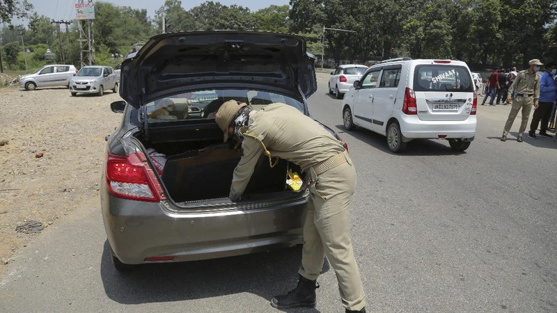Security personnel check vehicles on the Jammu-Pathankot highway after troops around midnight spotted two drones separately flying over Kaluchak military base on the outskirts of Jammu, India, Monday, June 28, 2021. India's military said it thwarted a major threat when it intercepted two drones flying over an army base in Indian-controlled Kashmir early Monday, a day after suspected explosives-laden drones were used to attack an air base in the disputed region. (AP Photo/Channi Anand)