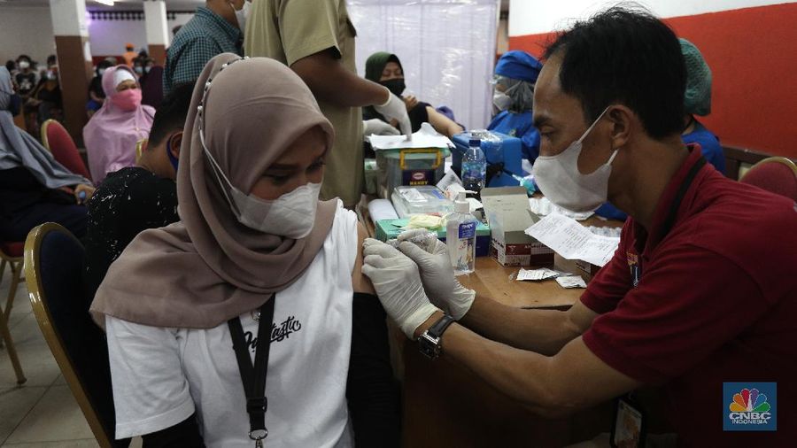 Warga mengikuti vaksinasi massal Covid-19 gelaran Pemkot, Jakarta Timur, di Gelanggang Olahraga (GOR) Ciracas, Senin (28/6/2021). Kouta vaksinasi di GOR Ciracas 1.000 per hari, terdiri dari 500 warga Kecamatan Ciracas dan 500 warga Kelurahan Pasar Rebo. Warga yang tidak memiliki KTP DKI Jakarta pun bisa mengikuti vaksinasi gratis dengan syarat membawa surat pengantar RT/RW. Bagi warga non DKI namun bekerja di Jakarta maka cukup membawa surat pengantar dari perusahaan tempatnya bekerja sebagai syarat mengikuti vaksinasi gratis. 
   (CNBC Indonesia/ Tri Susilo)