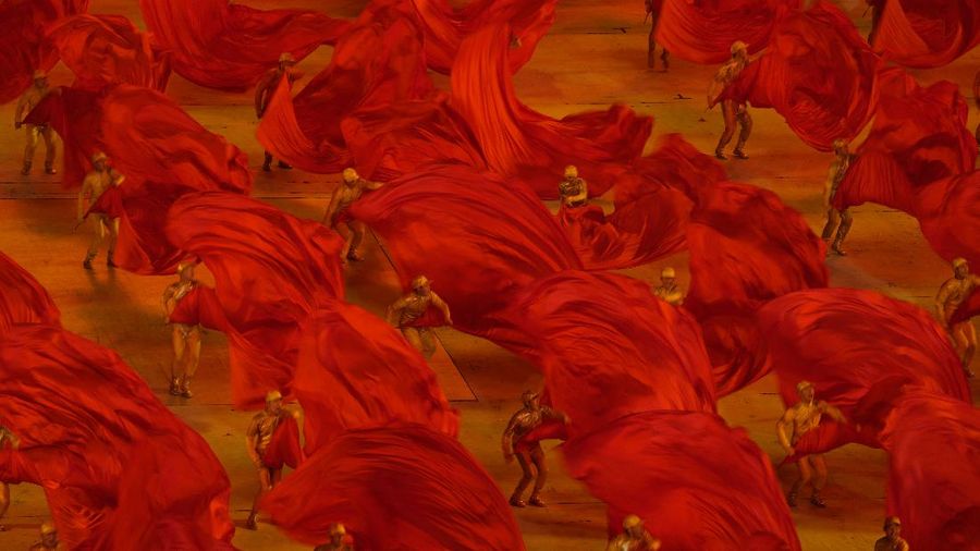 Performers dressed as rescue workers gather around the Communist Party flag during a gala show ahead of the 100th anniversary of the founding of the Chinese Communist Party in Beijing on Monday, June 28, 2021. China is marking the centenary of its ruling Communist Party this week by heralding what it says is its growing influence abroad, along with success in battling corruption at home. (AP Photo/Ng Han Guan)