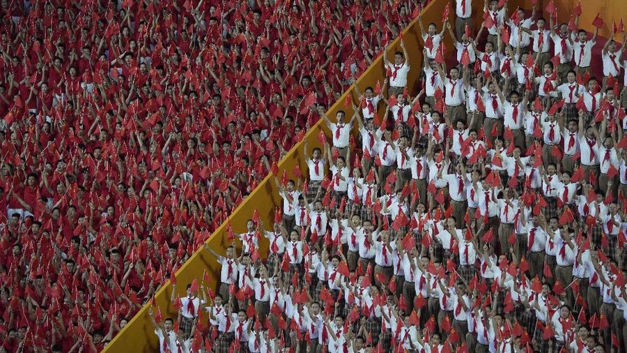 Performers dressed as rescue workers gather around the Communist Party flag during a gala show ahead of the 100th anniversary of the founding of the Chinese Communist Party in Beijing on Monday, June 28, 2021. China is marking the centenary of its ruling Communist Party this week by heralding what it says is its growing influence abroad, along with success in battling corruption at home. (AP Photo/Ng Han Guan)