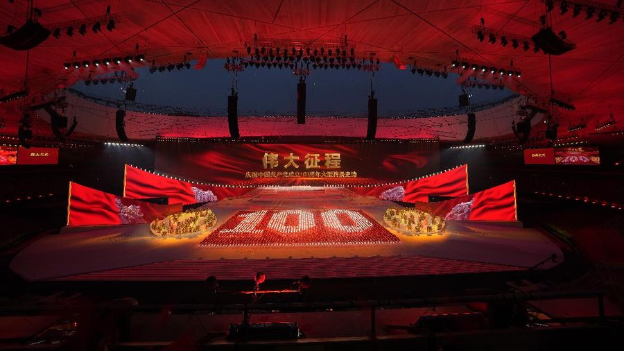 Performers dressed as rescue workers gather around the Communist Party flag during a gala show ahead of the 100th anniversary of the founding of the Chinese Communist Party in Beijing on Monday, June 28, 2021. China is marking the centenary of its ruling Communist Party this week by heralding what it says is its growing influence abroad, along with success in battling corruption at home. (AP Photo/Ng Han Guan)