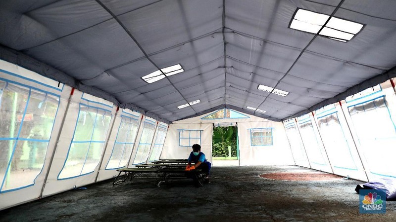 Pekerja RSUD Tarakan menyiapkan velbed di tenda darurat di SDN Negeri 02 Cideng, Jakarta, Selasa (29/6). Rumah Sakit Umum Daerah (RSUD) Tarakan kini menyiapkan tenda perawatan untuk pasien Corona di halaman IGD dan sekolah.Peminjaman lahan sekolah ini sudah berkoordinasi dengan Dinas Kesehatan DKI Jakarta. Tenda perawatan ini menyediakan 10 velbed. Sebelumnya, Dinas Kesehatan (Dinkes) DKI Jakarta menginstruksikan para direktur dan kepala rumah sakit se-DKI Jakarta menyediakan aula hingga tenda demi menampung pasien COVID-19. Arahan ini disampaikan dalam surat yang ditandatangani oleh Kepala Dinas Kesehatan DKI Jakarta Widyastuti pada 21 Juni 2021. Salah satu poin yang dipaparkan adalah meminta rumah sakit mendirikan tenda darurat berkapasitas besar di ruang terbuka di lingkungan RS.(վ/ Muhammad Sabki)