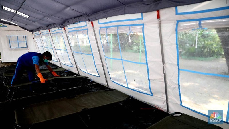Pekerja RSUD Tarakan menyiapkan velbed di tenda darurat di SDN Negeri 02 Cideng, Jakarta, Selasa (29/6). Rumah Sakit Umum Daerah (RSUD) Tarakan kini menyiapkan tenda perawatan untuk pasien Corona di halaman IGD dan sekolah.Peminjaman lahan sekolah ini sudah berkoordinasi dengan Dinas Kesehatan DKI Jakarta. Tenda perawatan ini menyediakan 10 velbed. Sebelumnya, Dinas Kesehatan (Dinkes) DKI Jakarta menginstruksikan para direktur dan kepala rumah sakit se-DKI Jakarta menyediakan aula hingga tenda demi menampung pasien COVID-19. Arahan ini disampaikan dalam surat yang ditandatangani oleh Kepala Dinas Kesehatan DKI Jakarta Widyastuti pada 21 Juni 2021. Salah satu poin yang dipaparkan adalah meminta rumah sakit mendirikan tenda darurat berkapasitas besar di ruang terbuka di lingkungan RS.(վ/ Muhammad Sabki)