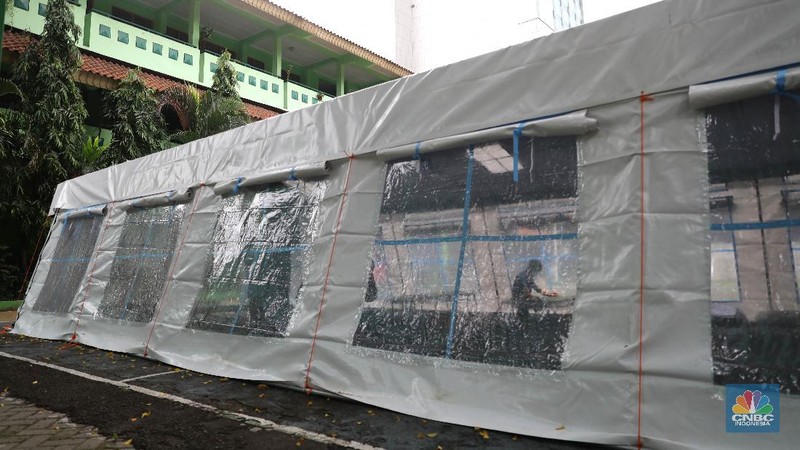 Pekerja RSUD Tarakan menyiapkan velbed di tenda darurat di SDN Negeri 02 Cideng, Jakarta, Selasa (29/6). Rumah Sakit Umum Daerah (RSUD) Tarakan kini menyiapkan tenda perawatan untuk pasien Corona di halaman IGD dan sekolah.Peminjaman lahan sekolah ini sudah berkoordinasi dengan Dinas Kesehatan DKI Jakarta. Tenda perawatan ini menyediakan 10 velbed. Sebelumnya, Dinas Kesehatan (Dinkes) DKI Jakarta menginstruksikan para direktur dan kepala rumah sakit se-DKI Jakarta menyediakan aula hingga tenda demi menampung pasien COVID-19. Arahan ini disampaikan dalam surat yang ditandatangani oleh Kepala Dinas Kesehatan DKI Jakarta Widyastuti pada 21 Juni 2021. Salah satu poin yang dipaparkan adalah meminta rumah sakit mendirikan tenda darurat berkapasitas besar di ruang terbuka di lingkungan RS.(վ/ Muhammad Sabki)