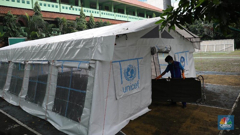 Pekerja RSUD Tarakan menyiapkan velbed di tenda darurat di SDN Negeri 02 Cideng, Jakarta, Selasa (29/6). Rumah Sakit Umum Daerah (RSUD) Tarakan kini menyiapkan tenda perawatan untuk pasien Corona di halaman IGD dan sekolah.Peminjaman lahan sekolah ini sudah berkoordinasi dengan Dinas Kesehatan DKI Jakarta. Tenda perawatan ini menyediakan 10 velbed. Sebelumnya, Dinas Kesehatan (Dinkes) DKI Jakarta menginstruksikan para direktur dan kepala rumah sakit se-DKI Jakarta menyediakan aula hingga tenda demi menampung pasien COVID-19. Arahan ini disampaikan dalam surat yang ditandatangani oleh Kepala Dinas Kesehatan DKI Jakarta Widyastuti pada 21 Juni 2021. Salah satu poin yang dipaparkan adalah meminta rumah sakit mendirikan tenda darurat berkapasitas besar di ruang terbuka di lingkungan RS.(վ/ Muhammad Sabki)