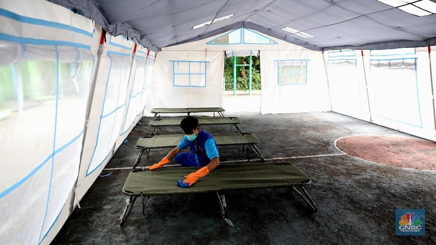 Pekerja RSUD Tarakan menyiapkan velbed di tenda darurat di SDN Negeri 02 Cideng, Jakarta, Selasa (29/6). Rumah Sakit Umum Daerah (RSUD) Tarakan kini menyiapkan tenda perawatan untuk pasien Corona di halaman IGD dan sekolah.Peminjaman lahan sekolah ini sudah berkoordinasi dengan Dinas Kesehatan DKI Jakarta. Tenda perawatan ini menyediakan 10 velbed. Sebelumnya, Dinas Kesehatan (Dinkes) DKI Jakarta menginstruksikan para direktur dan kepala rumah sakit se-DKI Jakarta menyediakan aula hingga tenda demi menampung pasien COVID-19. Arahan ini disampaikan dalam surat yang ditandatangani oleh Kepala Dinas Kesehatan DKI Jakarta Widyastuti pada 21 Juni 2021. Salah satu poin yang dipaparkan adalah meminta rumah sakit mendirikan tenda darurat berkapasitas besar di ruang terbuka di lingkungan RS.(վ/ Muhammad Sabki)