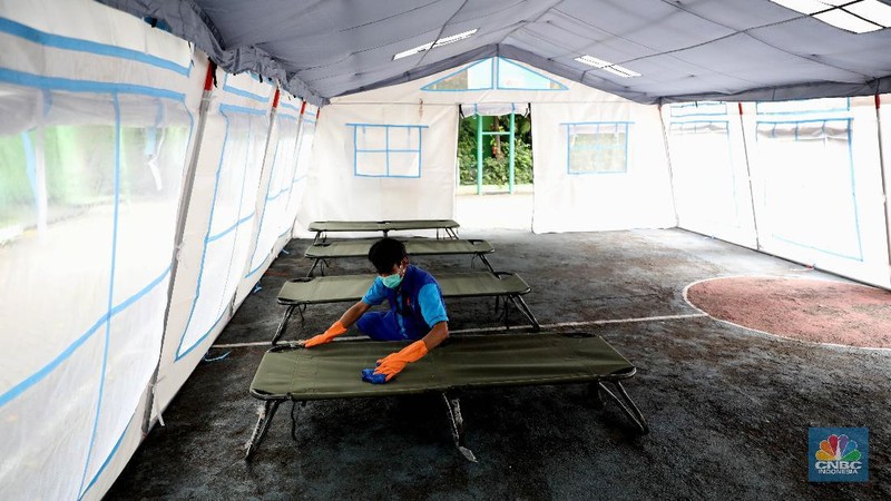Pekerja RSUD Tarakan menyiapkan velbed di tenda darurat di SDN Negeri 02 Cideng, Jakarta, Selasa (29/6). Rumah Sakit Umum Daerah (RSUD) Tarakan kini menyiapkan tenda perawatan untuk pasien Corona di halaman IGD dan sekolah.Peminjaman lahan sekolah ini sudah berkoordinasi dengan Dinas Kesehatan DKI Jakarta. Tenda perawatan ini menyediakan 10 velbed. Sebelumnya, Dinas Kesehatan (Dinkes) DKI Jakarta menginstruksikan para direktur dan kepala rumah sakit se-DKI Jakarta menyediakan aula hingga tenda demi menampung pasien COVID-19. Arahan ini disampaikan dalam surat yang ditandatangani oleh Kepala Dinas Kesehatan DKI Jakarta Widyastuti pada 21 Juni 2021. Salah satu poin yang dipaparkan adalah meminta rumah sakit mendirikan tenda darurat berkapasitas besar di ruang terbuka di lingkungan RS.(վ/ Muhammad Sabki)