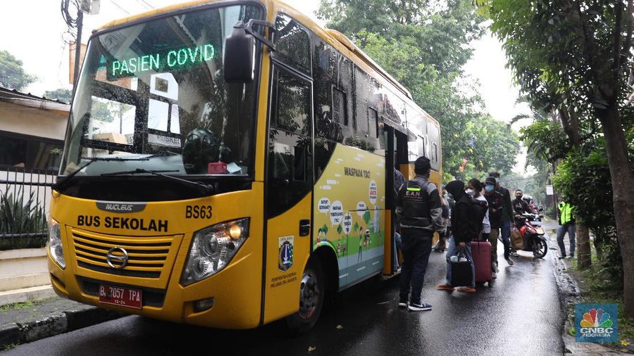 Petugas menggunakan Alat Pelindung Diri (APD) mendata pasien untuk masuk ke dalam bus sekolah di Puskesmas Kecamatan Setiabudi, Jakarta, Selasa (29/6/2021). Puskesmas Kecamatan Setiabudi  pada hari ini menjemput pasien Covid-19 sebanyak 50 orang. Puluhan pasien tersebut dibawa ke Wisma Atlet. Data Covid-19 hingga Senin (28/6/2021) mencatat total ada 2,1 juta orang positif di Indonesia. Sementara itu, total kematian sudah mencapai 57,561 orang. Pemerintah akan mengumumkan revisi aturan terkait pemberlakuan pembatasan kegiatan masyarakat (PPKM) berbasis mikro pada petang ini. Presiden Joko Widodo (Jokowi) memutuskan akan memberlakukan PPKM Darurat untuk mengatasi lonjakan kasus Covid-19. Kebijakan ini tidak lepas dari kondisi kasus positif Covid-19 harian di Indonesia sudah mencapai 20 ribuan per hari, semakin naik dibanding sebelumnya. Sementara itu jika merujuk pada data worldmeter, Indonesia berada di urutan ke 17. Adapun jumlah tes yang dilakukan terbilang minim hanya 71.051 per 1 juta penduduk. Jauh dibandingkan negara lain yang mencapai ratusan ribu per 1 juta penduduk. (CNBC Indonesia/ Muhammad Sabki)