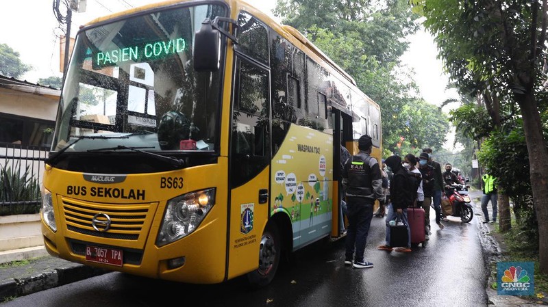 Petugas menggunakan Alat Pelindung Diri (APD) mendata pasien untuk masuk ke dalam bus sekolah di Puskesmas Kecamatan Setiabudi, Jakarta, Selasa (29/6/2021). Puskesmas Kecamatan Setiabudi  pada hari ini menjemput pasien Covid-19 sebanyak 50 orang. Puluhan pasien tersebut dibawa ke Wisma Atlet. Data Covid-19 hingga Senin (28/6/2021) mencatat total ada 2,1 juta orang positif di Indonesia. Sementara itu, total kematian sudah mencapai 57,561 orang. Pemerintah akan mengumumkan revisi aturan terkait pemberlakuan pembatasan kegiatan masyarakat (PPKM) berbasis mikro pada petang ini. Presiden Joko Widodo (Jokowi) memutuskan akan memberlakukan PPKM Darurat untuk mengatasi lonjakan kasus Covid-19. Kebijakan ini tidak lepas dari kondisi kasus positif Covid-19 harian di Indonesia sudah mencapai 20 ribuan per hari, semakin naik dibanding sebelumnya. Sementara itu jika merujuk pada data worldmeter, Indonesia berada di urutan ke 17. Adapun jumlah tes yang dilakukan terbilang minim hanya 71.051 per 1 juta penduduk. Jauh dibandingkan negara lain yang mencapai ratusan ribu per 1 juta penduduk. (CNBC Indonesia/ Muhammad Sabki)