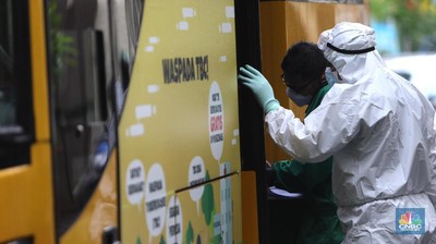 Penjemputan Pasien Covid-19. Petugas menggunakan Alat Pelindung Diri (APD) mendata pasien untuk masuk ke dalam bus sekolah di Puskesmas Kecamatan Setiabudi, Jakarta, Selasa (29/6/2021). Puskesmas Kecamatan Setiabudi pada hari ini menjemput pasien Covid-19 sebanyak 50 orang. Puluhan pasien tersebut dibawa ke Wisma Atlet. Data Covid-19 hingga Senin (28/6/2021) mencatat total ada 2,1 juta orang positif di Indonesia. Sementara itu, total kematian sudah mencapai 57,561 orang. Pemerintah akan mengumumkan revisi aturan terkait pemberlakuan pembatasan kegiatan masyarakat (PPKM) berbasis mikro pada petang ini. Presiden Joko Widodo (Jokowi) memutuskan akan memberlakukan PPKM Darurat untuk mengatasi lonjakan kasus Covid-19. Kebijakan ini tidak lepas dari kondisi kasus positif Covid-19 harian di Indonesia sudah mencapai 20 ribuan per hari, semakin naik dibanding sebelumnya. Sementara itu jika merujuk pada data worldmeter, Indonesia berada di urutan ke 17. Adapun jumlah tes yang dilakukan terbilang minim hanya 71.051 per 1 juta penduduk. Jauh dibandingkan negara lain yang mencapai ratusan ribu per 1 juta penduduk. (CNBC Indonesia/ Muhammad Sabki)